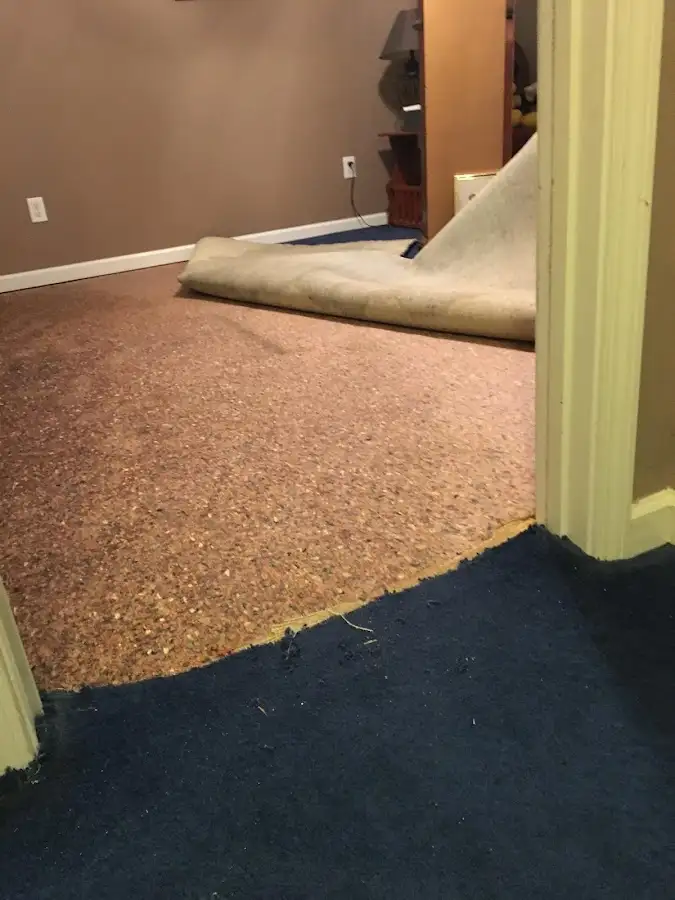 Carpet pad removal revealing water damage during Water Mitigation Services in Summerfield